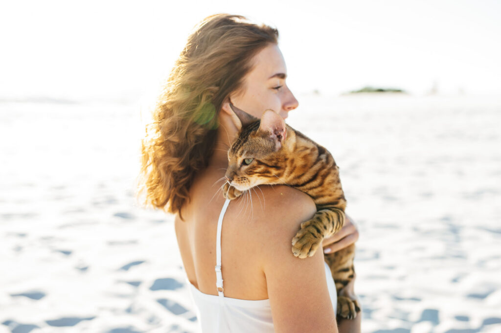 femme avec son chat dans les bras devant la mer
